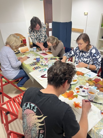 Chlapec na tvořivém kroužku vytváří obrázek na tričku.