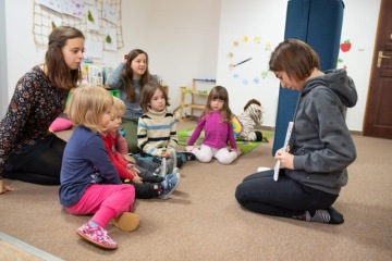 Děti pozorně sledují příběh při společném čtení.