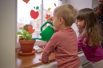 Děti se učí, jak zalévat květiny.