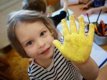 Holčička mává rukou od barvy.